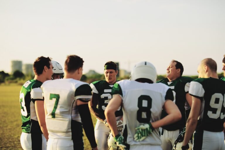 American football team standing in a huddle before practice